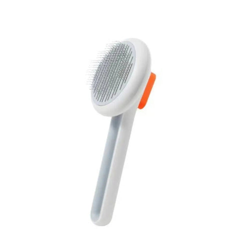 Witte huisdierborstel met oranje knop en lange handgreep.