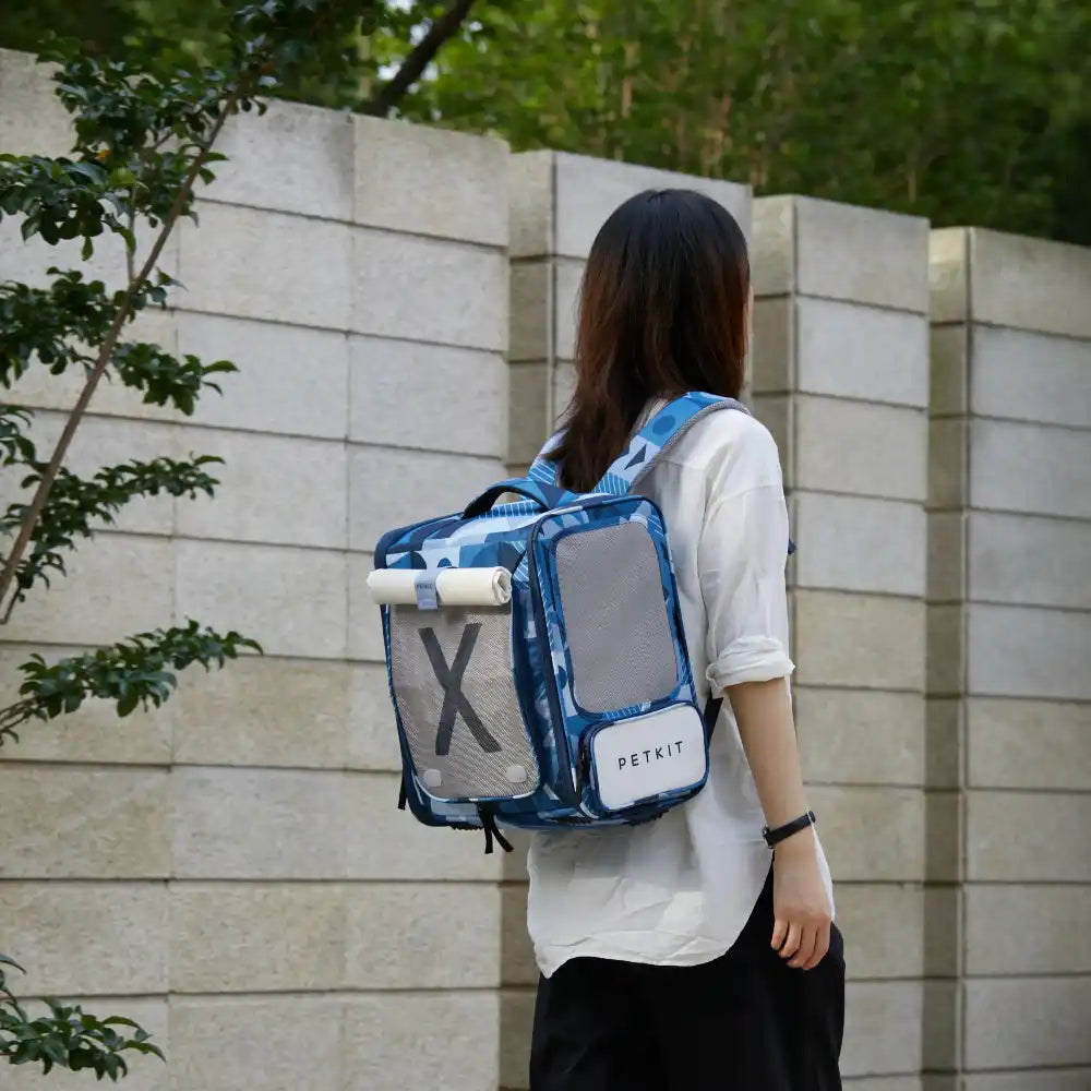 Vrouw draagt PETKIT Breezy XZone huisdierdrager rugzak blauw met mesh ventilatie voor katten en kleine huisdieren