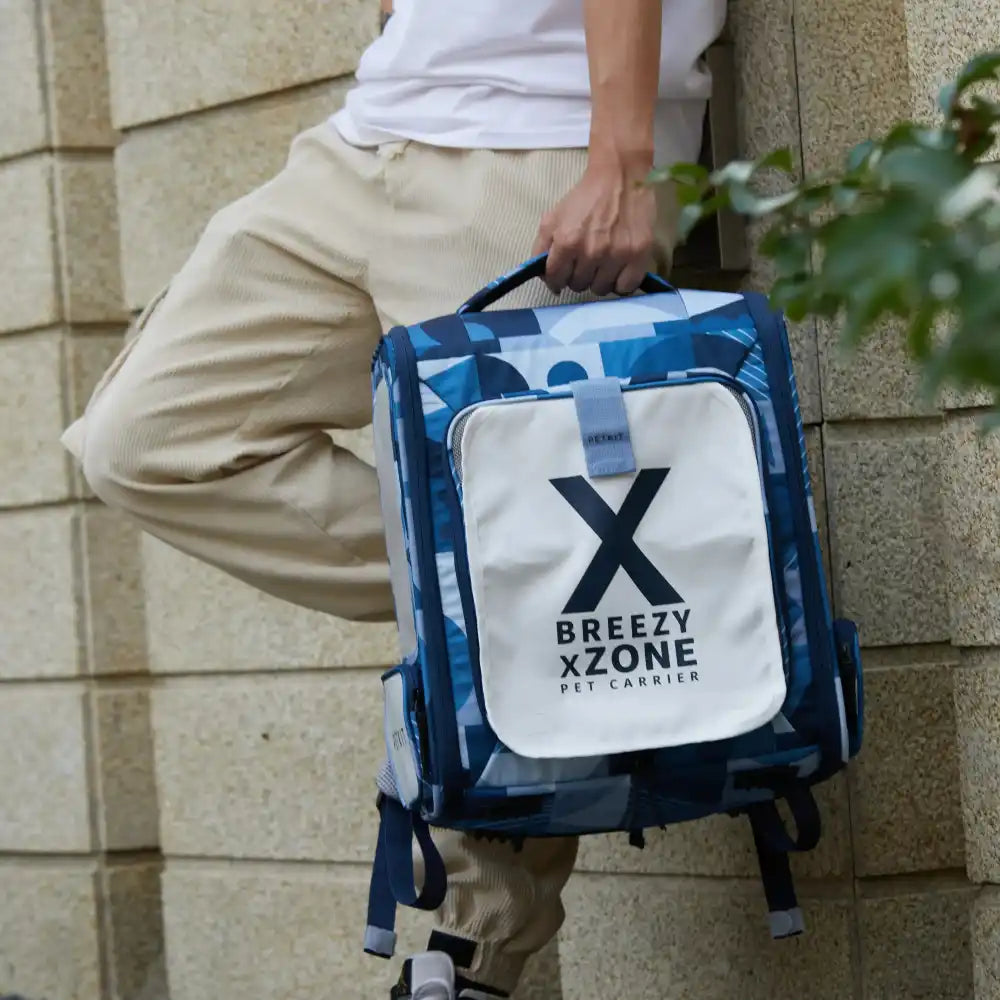 Man holding a PETKIT Breezy XZone blue pet carrier backpack with white front panel, modern portable design for pets